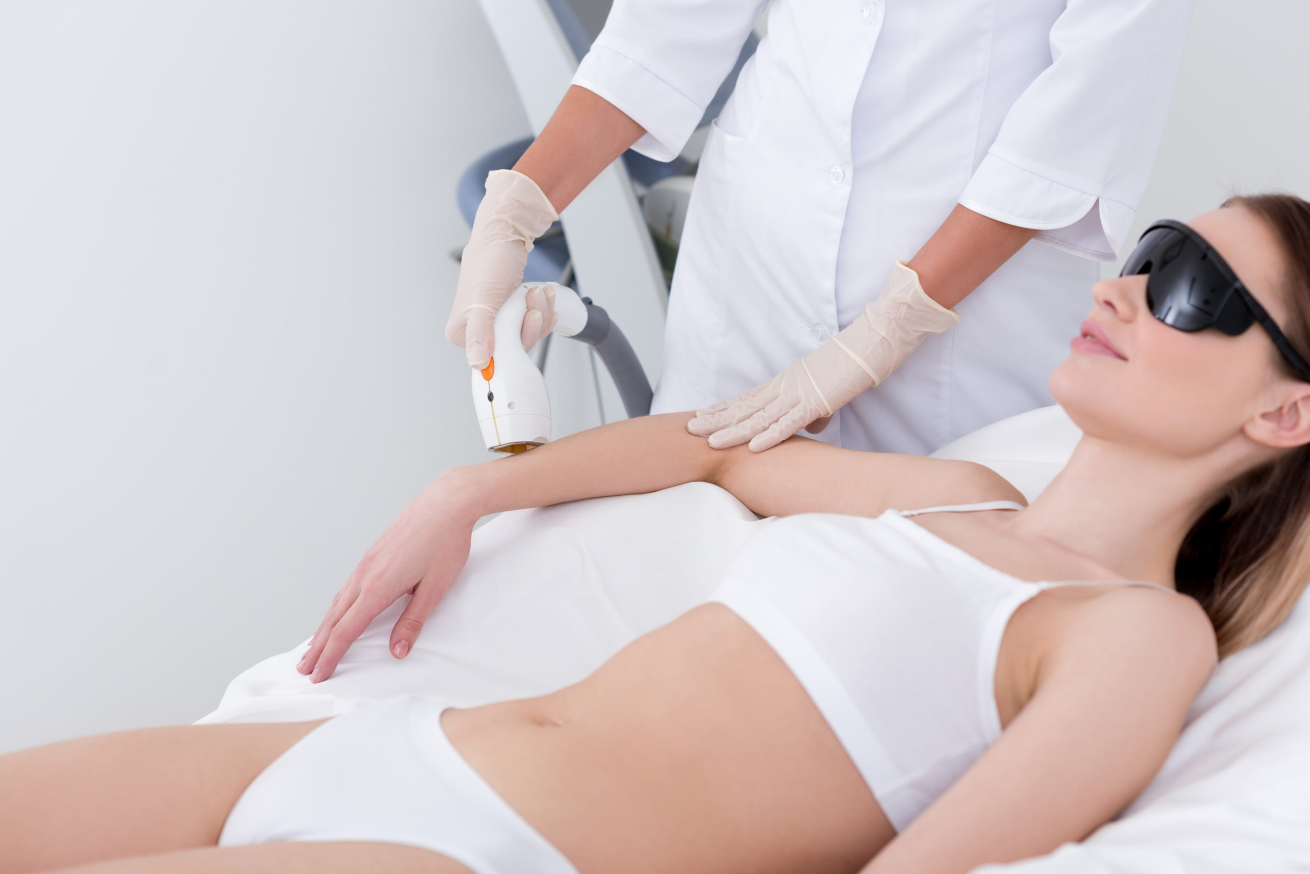 laser-cropped shot of woman getting laser hair removal procedure on arm in salon